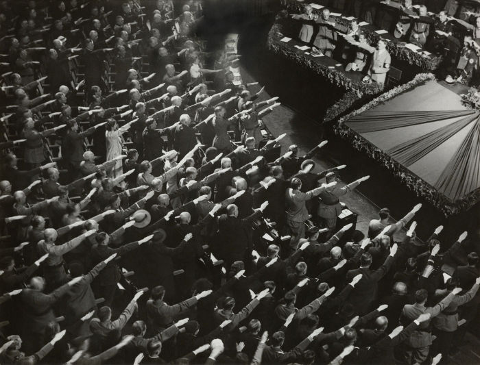 Pessoas saudando Hitler durante reunião nazista. [1]